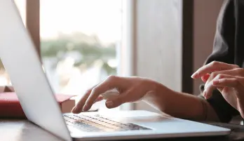 Imagem de um notebook com uma mulher usando-o