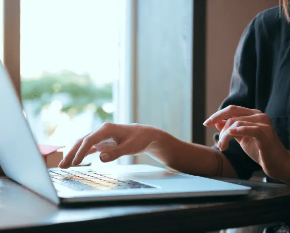 Imagem de um notebook com uma mulher usando-o